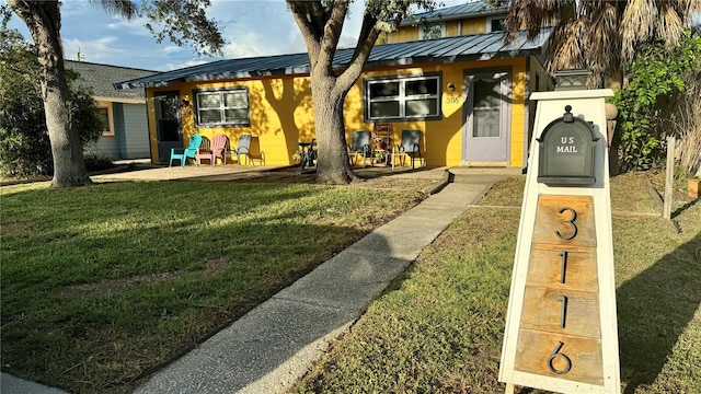 view of front of property featuring a patio and a front yard