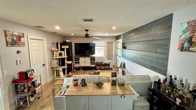 kitchen with ceiling fan, white cabinetry, light hardwood / wood-style floors, and wooden counters