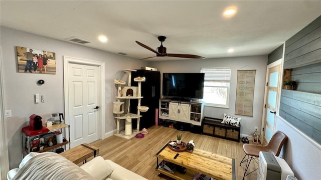 living room featuring ceiling fan and hardwood / wood-style floors