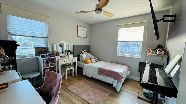 bedroom featuring multiple windows, ceiling fan, and light hardwood / wood-style flooring