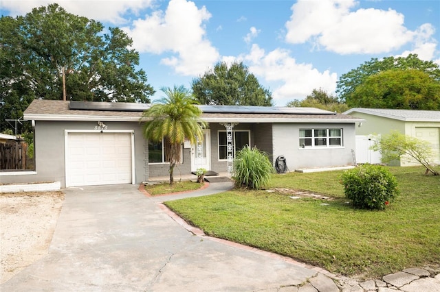 single story home with solar panels, a front yard, and a garage