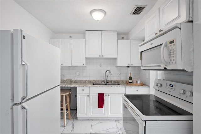 kitchen with sink, white appliances, white cabinetry, and backsplash