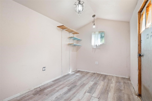 unfurnished room featuring lofted ceiling and light hardwood / wood-style flooring