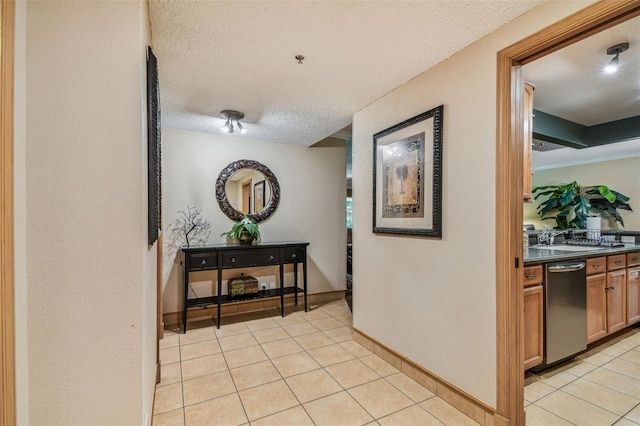 hallway with sink, a textured ceiling, and light tile patterned floors