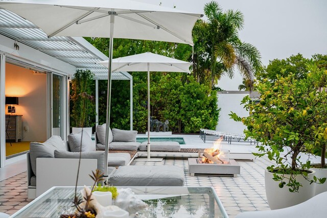 440 64th Ave, St Pete Beach, FL 33706 - view of patio / terrace with an outdoor living space with a fire pit