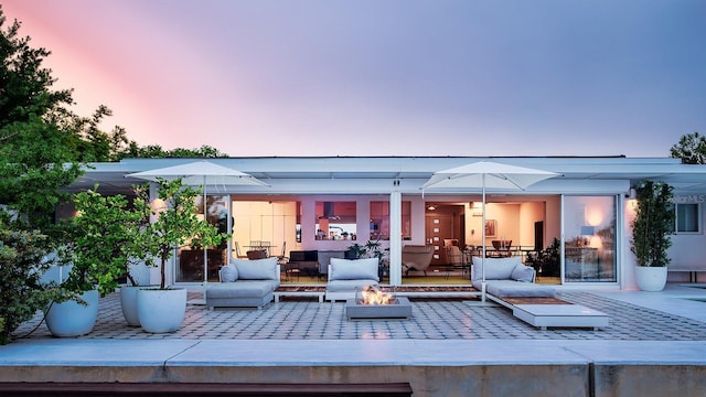 440 64th Ave, St Pete Beach, FL 33706 - back of house at dusk featuring an outdoor living space with a fire pit and a patio