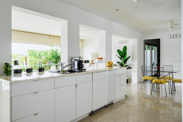440 64th Ave, St Pete Beach, FL 33706 - kitchen featuring dark speckled floor, plenty of natural light, white cabinetry, and light countertops