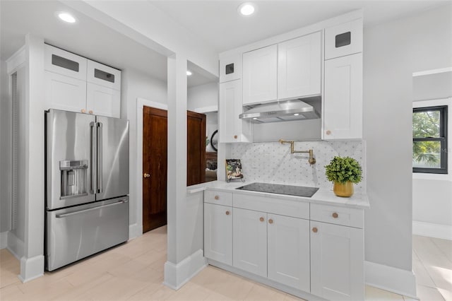 kitchen featuring black electric cooktop, tasteful backsplash, high end refrigerator, and white cabinets