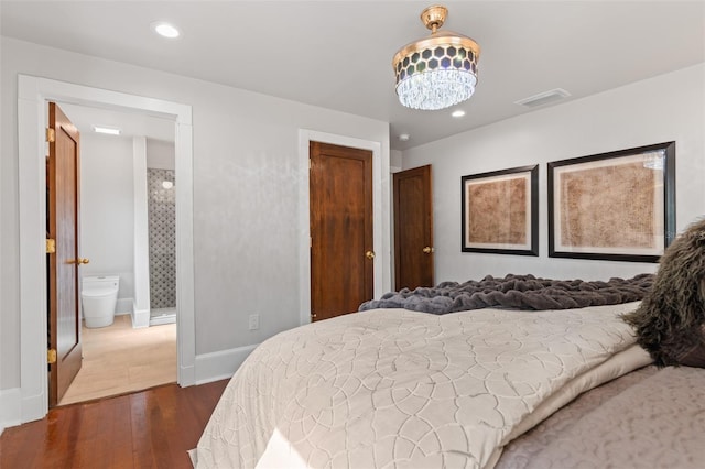 bedroom with dark wood-type flooring and an inviting chandelier