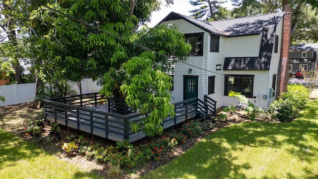 rear view of property featuring a yard and a deck