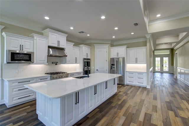 kitchen with appliances with stainless steel finishes, backsplash, white cabinets, and dark wood-type flooring