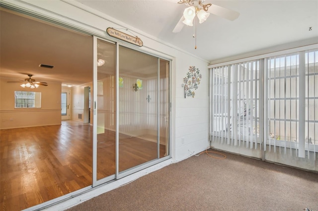 unfurnished sunroom with ceiling fan