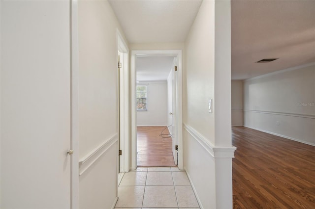 hall with light tile patterned flooring and crown molding