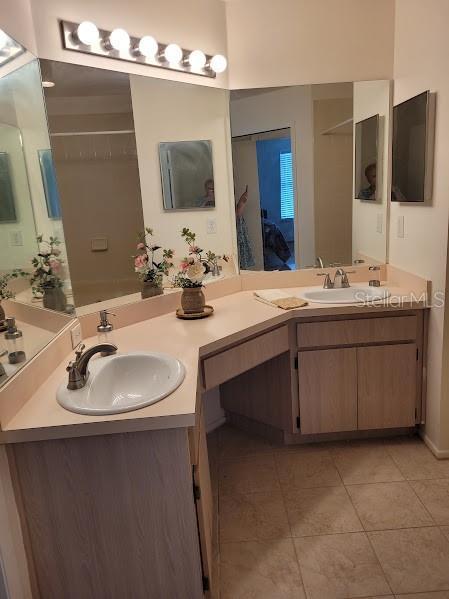 bathroom with tile patterned flooring, vanity, and walk in shower