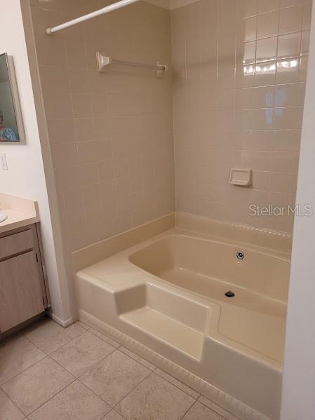 bathroom featuring tile patterned flooring, vanity, and bathtub / shower combination