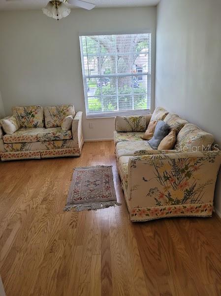 living room featuring light hardwood / wood-style floors and ceiling fan