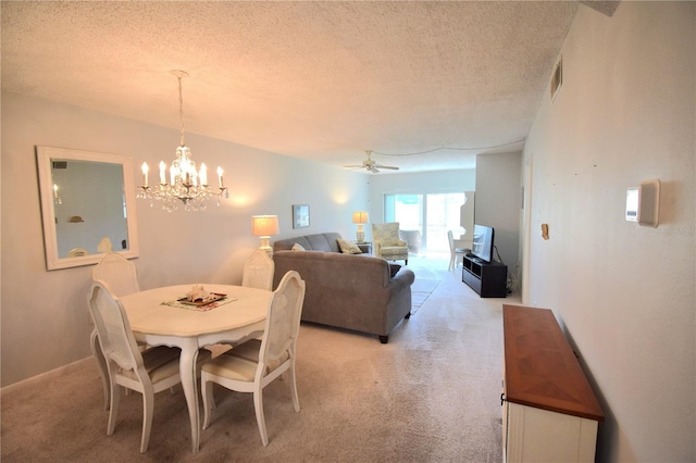 carpeted dining space featuring ceiling fan with notable chandelier and a textured ceiling