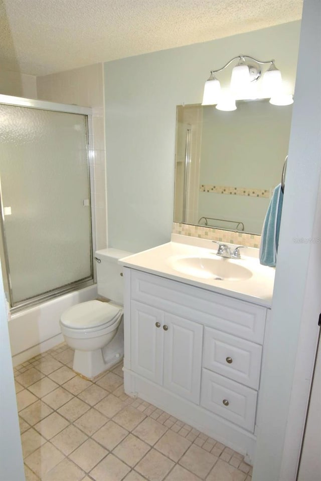 full bathroom featuring vanity, shower / bath combination with glass door, a textured ceiling, and toilet