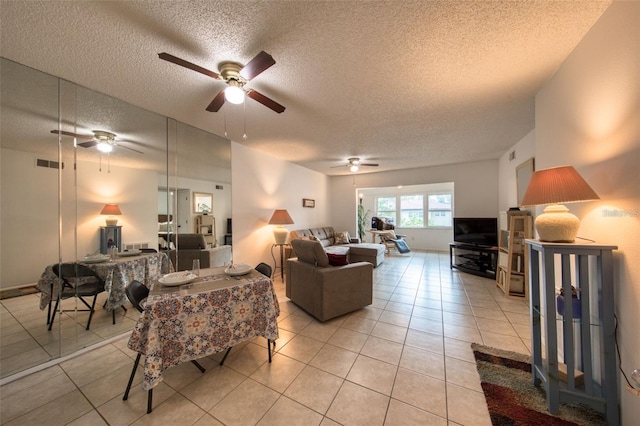 living room featuring ceiling fan, a textured ceiling, and light tile patterned floors