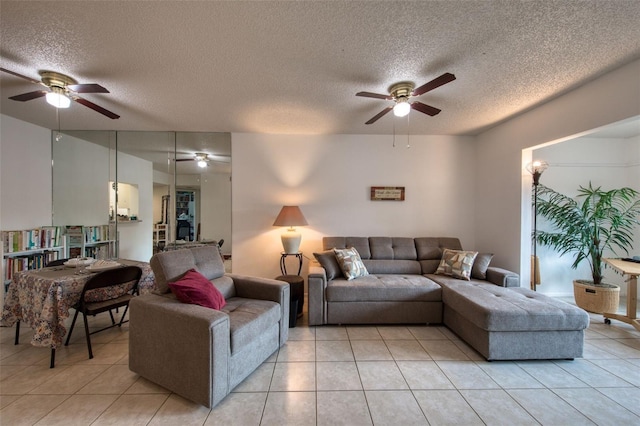 living room featuring ceiling fan, a textured ceiling, and light tile patterned floors