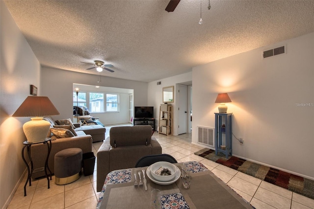 living room featuring a textured ceiling, ceiling fan, and light tile patterned floors