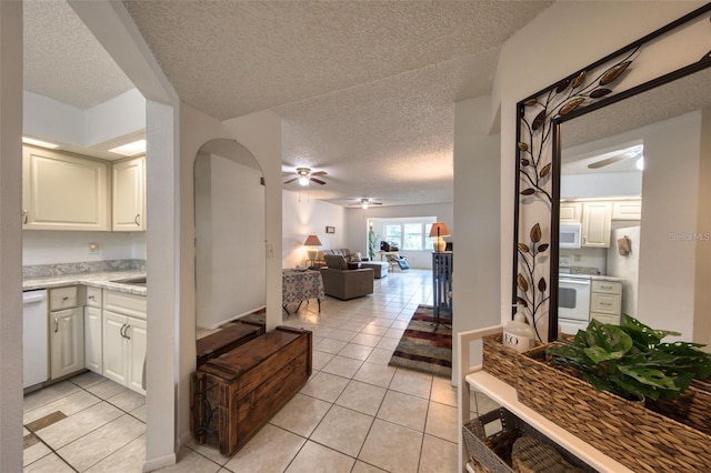 kitchen with light tile patterned floors, white cabinetry, and white appliances