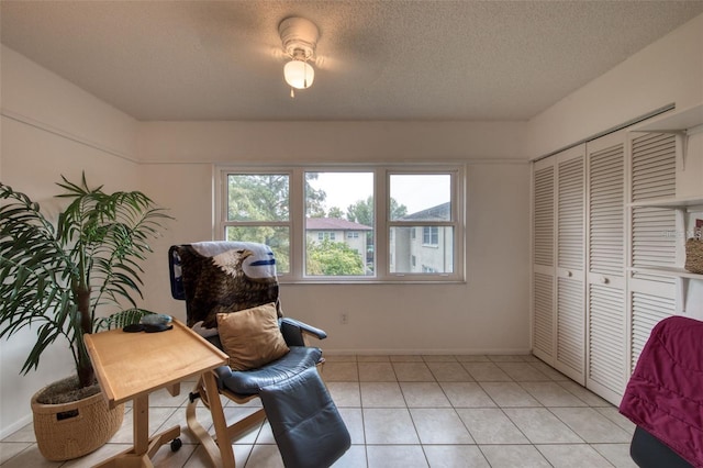 living area with a textured ceiling and light tile patterned floors