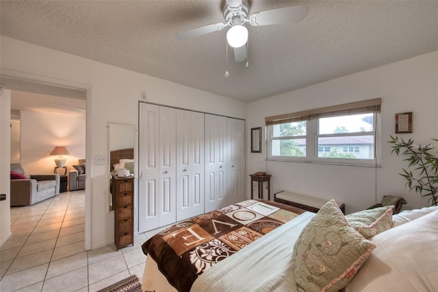 tiled bedroom featuring a textured ceiling, ceiling fan, and a closet