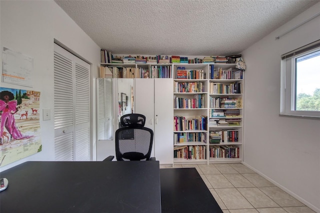 office space with a textured ceiling and light tile patterned flooring