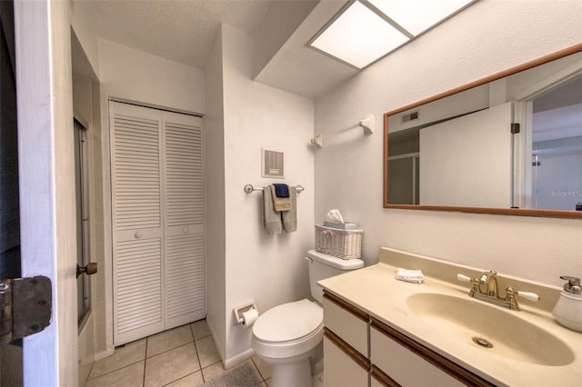 bathroom featuring toilet, a textured ceiling, tile patterned floors, and vanity