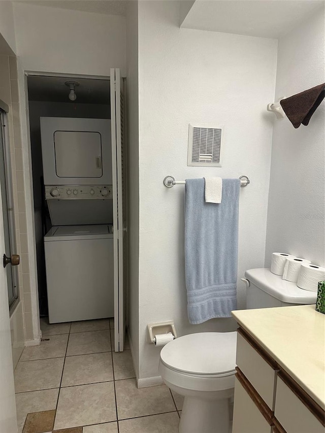 full bathroom with toilet, tile patterned floors, stacked washing maching and dryer, vanity, and shower / bath combination with glass door