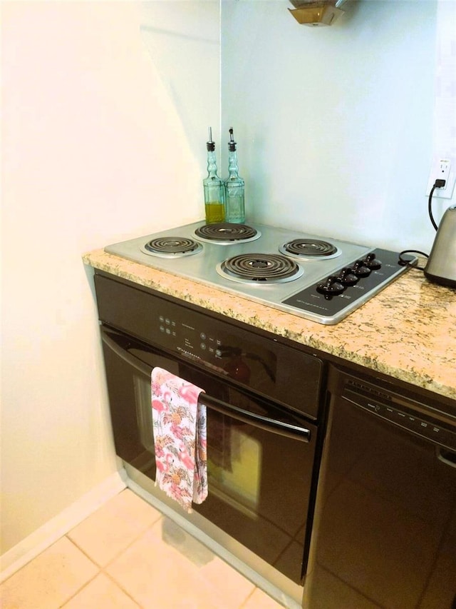 kitchen with light tile patterned flooring, black appliances, and light stone countertops