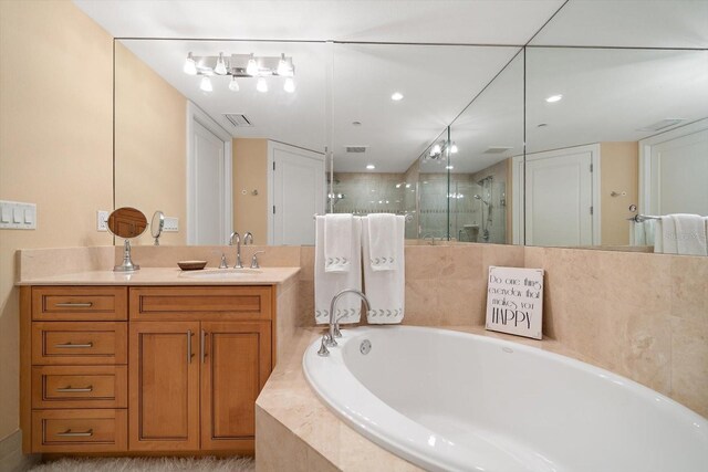 bathroom featuring vanity and separate shower and tub