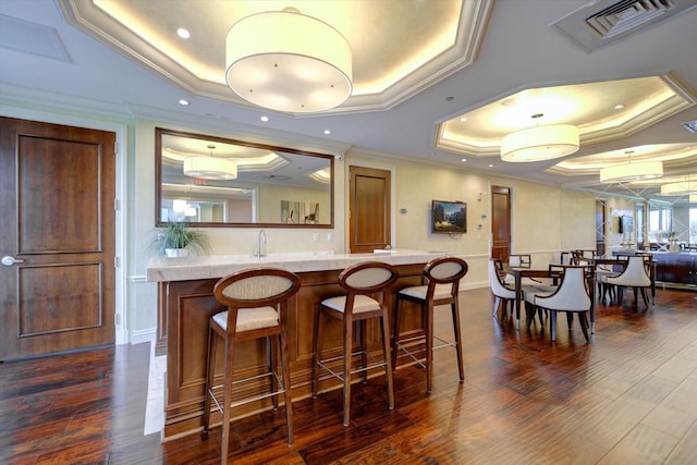 bar featuring ornamental molding, dark wood-type flooring, plenty of natural light, and a tray ceiling