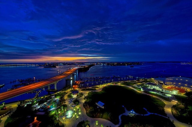 aerial view at dusk featuring a water view