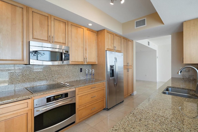 kitchen featuring light tile patterned flooring, tasteful backsplash, stainless steel appliances, sink, and light stone counters