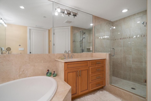 bathroom featuring recessed lighting, visible vents, vanity, a bath, and a stall shower