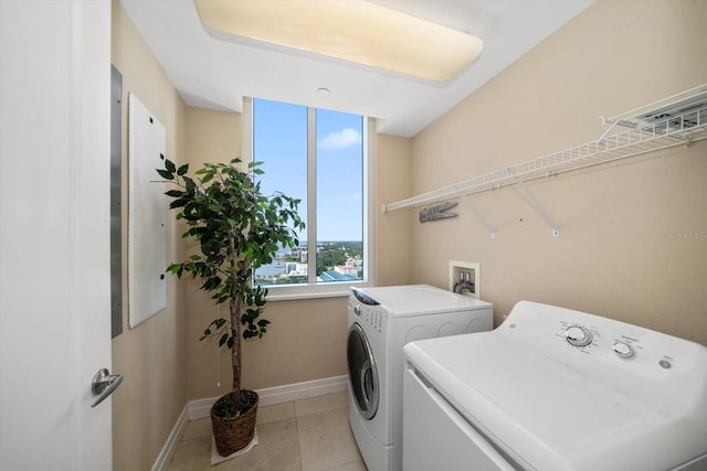 washroom featuring washing machine and dryer and light tile patterned floors