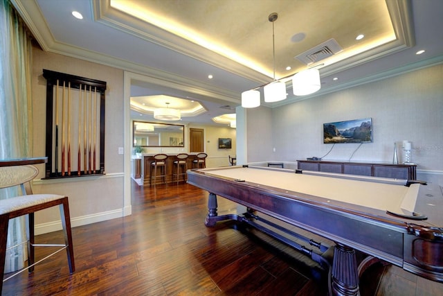 rec room with dark wood-type flooring, visible vents, baseboards, ornamental molding, and a tray ceiling