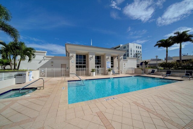 view of swimming pool featuring a community hot tub and a patio