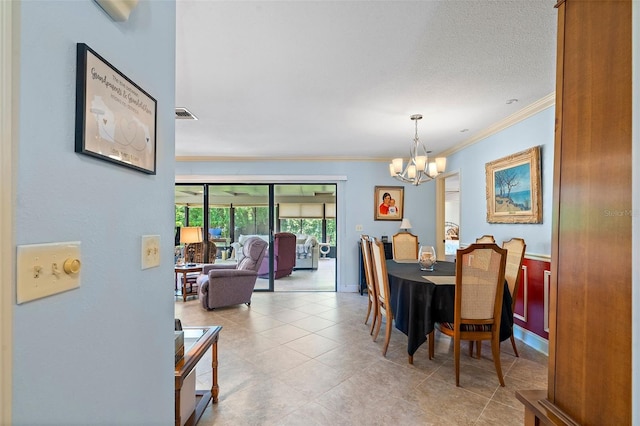 dining area with a textured ceiling, crown molding, and a notable chandelier