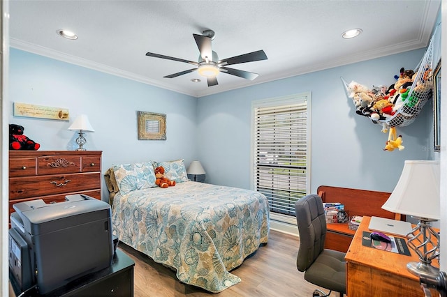 bedroom featuring light wood-type flooring, ceiling fan, and crown molding