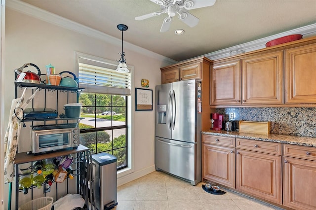 kitchen featuring stainless steel fridge, light stone countertops, a wealth of natural light, tasteful backsplash, and light tile patterned flooring