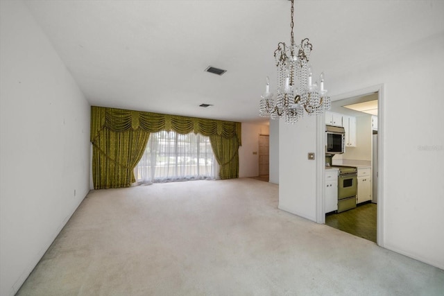 empty room featuring carpet and an inviting chandelier