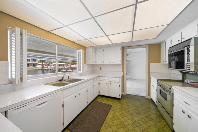 kitchen with stainless steel electric stove, white cabinetry, sink, and white dishwasher