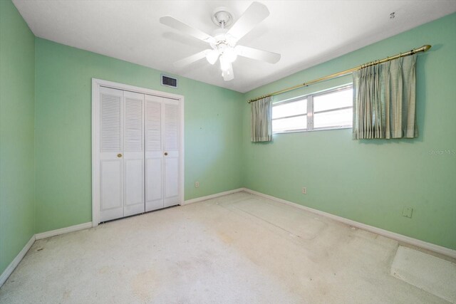 unfurnished bedroom featuring ceiling fan, a closet, and light carpet