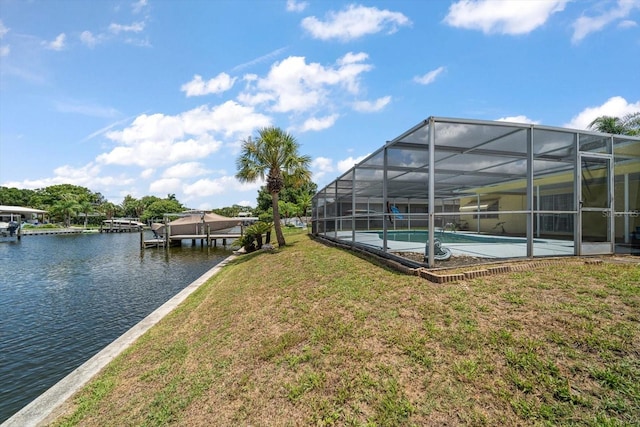 view of dock featuring glass enclosure, a yard, and a water view