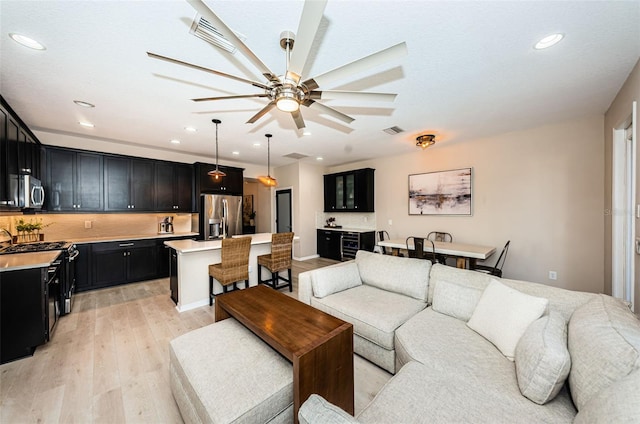 living room with light wood-type flooring and ceiling fan