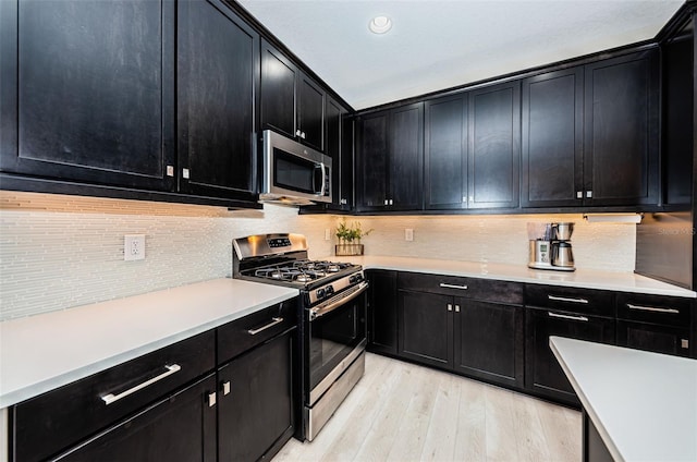 kitchen with decorative backsplash, light hardwood / wood-style flooring, and stainless steel appliances