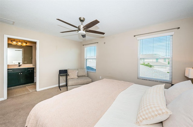 carpeted bedroom featuring ceiling fan, sink, and ensuite bathroom